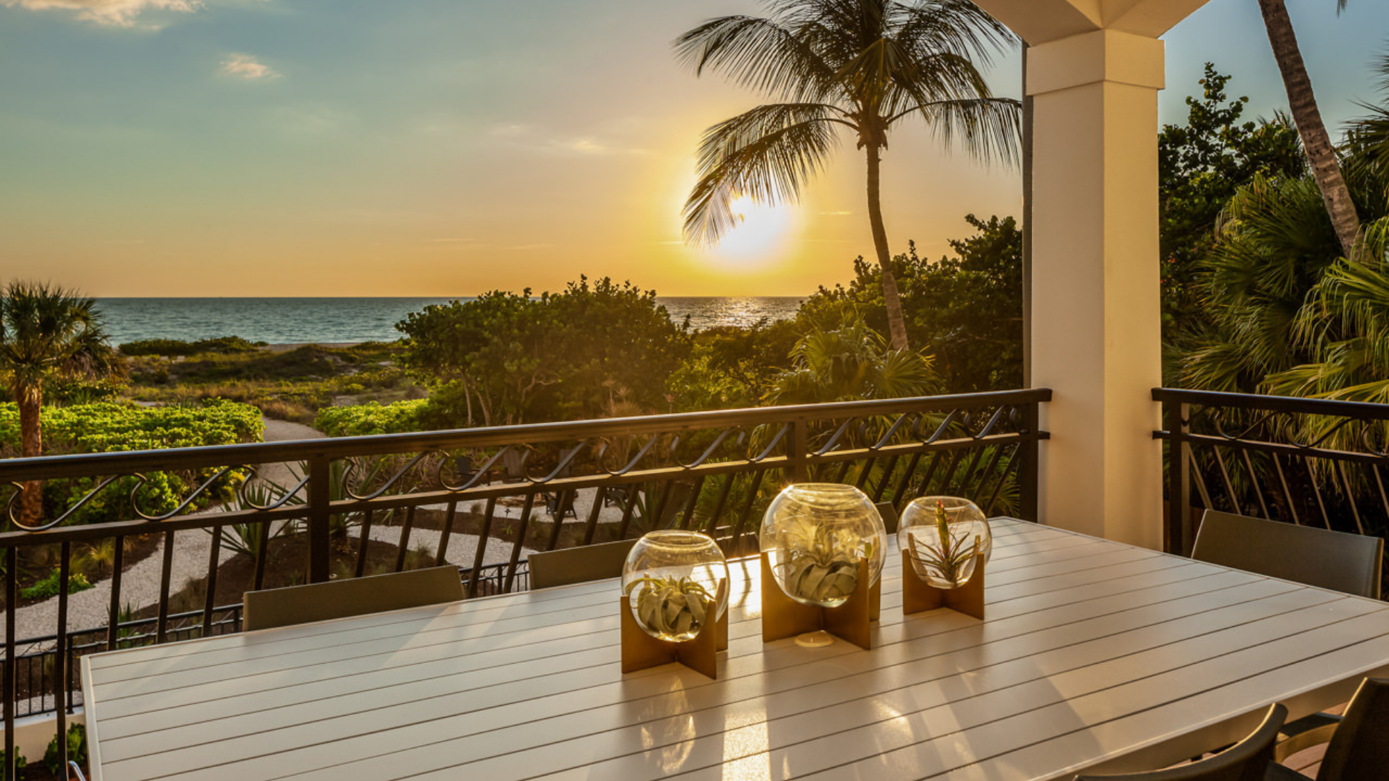 View of sunset and ocean from deck with table and candles