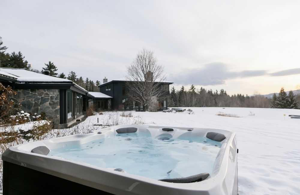 Hot tub outside in the snow with Mountains in the background