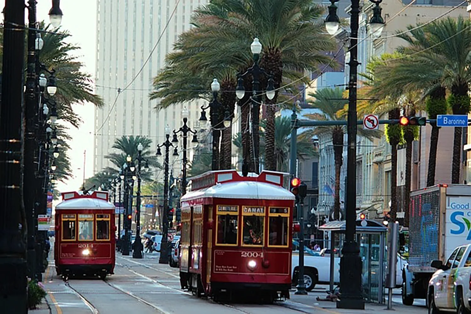 Downtown New Orleans street with red street trollies and Palm Trees